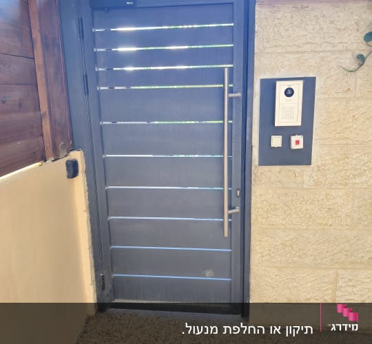 דלת מתכת עם קודן מותקן על קיר אבן